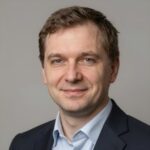 Портрет уверенного бизнесмена компании Авто RST на размытом фоне в студийном освещении